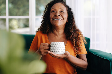 Poster - Retired woman relaxing with a warm cup of tea at home