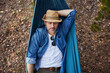 © baranq - Overhead portrait of handsome adult man sleeping in hammock in forest taking nap during hiking trip