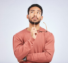 Leinwandbilder - Decision, thinking and asian man in studio with glasses, questions and brainstorming on grey background. Why, idea and male person with emoji, body language or choice gesture, puzzled or solution