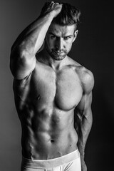 Wall Mural - Black and white photo shoot of handsome man with perfect body.