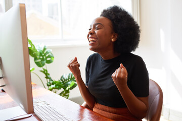 Beautiful young Black woman in tech cheers, celebrate successful mobile app