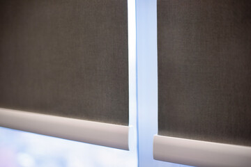 Poster - Roller blinds closeup on the window. Selective fokus. Motorized roller shades. Gray color, texture material. Two fabric webs through an intermediate bracket.