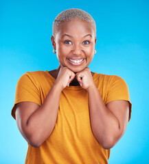 Poster - Portrait, smile and black woman with hand on face with confidence in blue studio background. Beauty, cosmetic and girl with fashion or positive mindset for wellness or happiness and excited face.