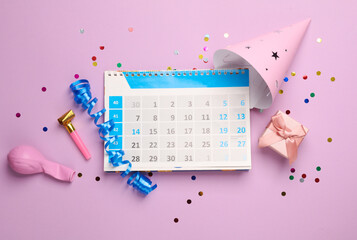 Calendar with birthday accessories on pink background. Flat lay