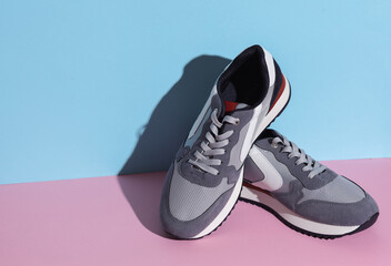 Wall Mural - Sports sneakers on a blue pink background. Creative layout, minimalism