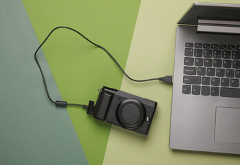 modern camera connected by cable to laptop. top view