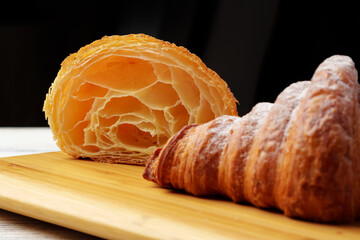 Wall Mural - Freshly baked croissant with powdered sugar on wooden board