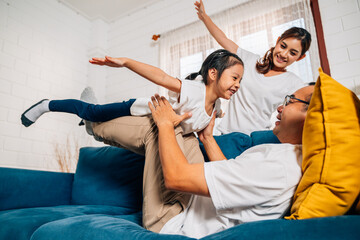 Father mother and daughter doing exercise in living room at home