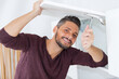 © auremar - man posing while mending cabinet door