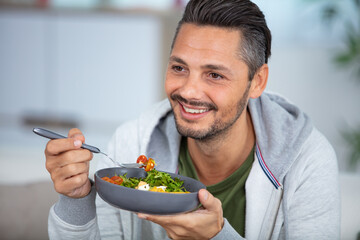 young man eating a healthy salad