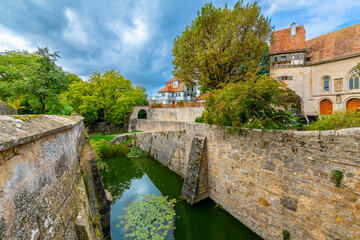 Wall Mural - View from near the Klingentor Blade Gate near Saint Wolfgang Church of a protective moat and medieval buildings inside the walls of Rothenburg ob der Tauber, Germany.