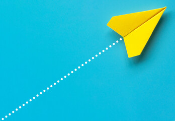 Wall Mural - Top view of yellow paper airplane on blue background. Air transport and copy space.
