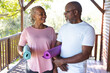 © Wavebreak Media - Portrait of happy senior african american couple holding yoga exercise mats on terrace
