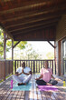 © Wavebreak Media - Focused senior african american couple practicing yoga on mats on terrace, copy space