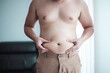 © Naknakhone - Fat man with a big belly worries about his body. Men are more likely to Clog arteries, Man at risk for diabetes, Belly Fat. .Close-up part of the body