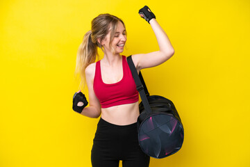 Wall Mural - Young sport caucasian woman with sport bag isolated background celebrating a victory