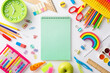 © ActionGP - Immerse yourself in concept of education for young learners with this top-down photo of colorful array of child stationery on white isolated backdrop, blank notepad page perfect for text or promotion