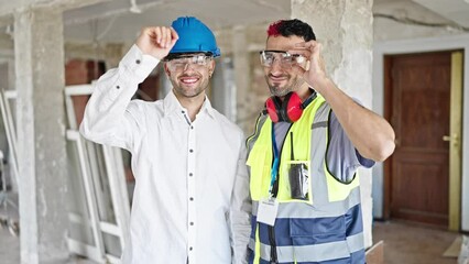 Wall Mural - Two men builder and architect smiling confident standing together at construction site