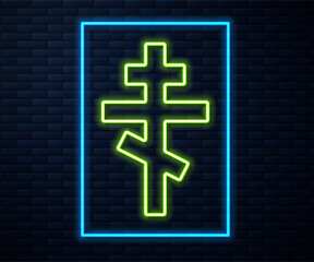 Sticker - Glowing neon line Christian cross icon isolated on brick wall background. Church cross. Vector