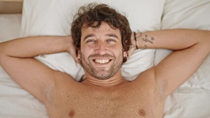 Sticker - Young hispanic man relaxed on bed smiling shirtless at bedroom