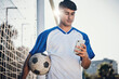 © Daniels C/peopleimages.com - Soccer ball, phone and man on field for competition, training or fitness news, social media chat and blog. Football player or person search on mobile app for sports information, health or goals check