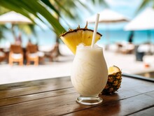 Closeup Photo Of Fresh Cold Alcoholic Fruit Pina Colada Cocktail Drink Glass With Cream And Pineapple With Blurry Tropical Beach Bar In The Background. Generative AI
