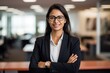 © Yuliia - Indian successful confident Arabian businesswoman worker lady boss in glasses and formal suit female leader girl business woman intern employer posing crossed hands company office corporate portrait