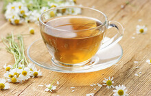 Chamomile Herbal Tea In A Glass Cup With Flowers On Wooden Rustic Background, Closeup, Winter Cold Healing Drink, Natural Medicine And Naturopathy Concept