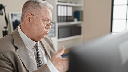 Canvas Print - Middle age grey-haired man business worker using computer speaking at office