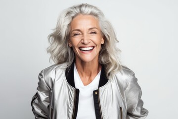 Wall Mural - cheerful senior woman in leather jacket smiling at camera isolated on grey