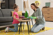 © New Africa - Spring cleaning. Mother and daughter tidying up living room together