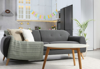 Poster - Gray sofa and white wooden table in kitchen