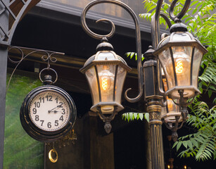 clock with three lit lanterns