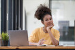 © Songsak C - A beautiful African American girl, student or businesswoman sitting at a desk and writing.