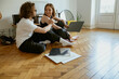 © Kostiantyn - Young couple sitting on floor and listening music on vinyl player with different vinyl records