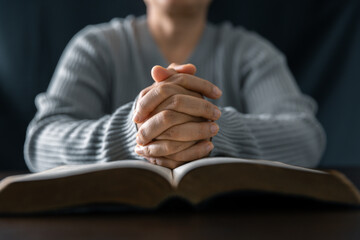 Wall Mural - Woman engaged in prayer. In the quiet darkness of a sacred room, she seeks solace, spiritual connection. Immerse yourself in the tranquility and mindfulness of this profound moment.