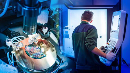 Poster - Production of digital boards. Microchip making machine. Factory worker with back to camera. Man controls production of digital circuit boards. Industrial equipment. Manufacturing of digital boards