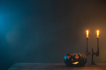 Wall Mural - halloween pumpkins with burning candles on dark background