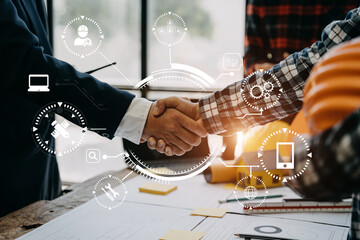 Construction workers, architects and engineers shake hands while working for teamwork and cooperation after completing an agreement in an office facility, successful cooperation concept.