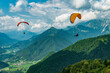 Colorful paraglider wings fly in the mountains near Tolmin, Slovenia.