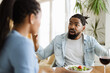 © Goran - Angry black man arguing with his wife during lunch at home