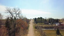 Aerial Upward Shot Of Dirt Road Passing Through Trees On Sunny Day - Billings, Montana