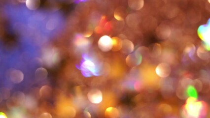 Wall Mural - Gold bokeh lights on blue background. Glowing golden defocused circles and stars in motion. Natural blurry glitter effect. Abstract colorful Christmas bokeh background. 