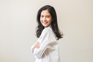 Wall Mural - Smile positive, happy asian young woman wearing casual shirt, portrait of beautiful female with black long hair feeling prond, standing crossed arms looking at camera, isolated on white background.