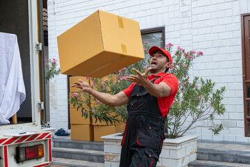 Portrait of two movers unloading boxes and furniture from a pickup truck.
