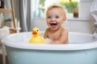 Funny little girl playing in a children's bathtub with a rubber duck, water and foam.