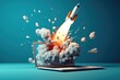 © visoot - Laptop and rocket taking off from the screen, Blue background, Startup concept.