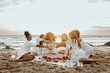© Prostock-studio - Group of young women toasting with champagne, having bachelorette party celebration on the beach