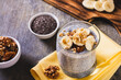 © elenarui - Chia seeds pudding with fresh banana and walnuts in a glass on the table
