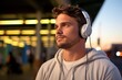 © SayLi - a closeup photo portrait of handsome white teenage guy walking and listening to music with over-ear headphones. blurry city street in the background. Generative AI